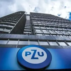 Budynek PZU z widocznym logo, widziany z dołu pod błękitnym niebem.