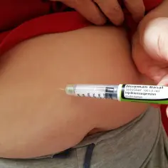 Osoba podaje sobie zastrzyk insuliny za pomocą peny SoloStar.