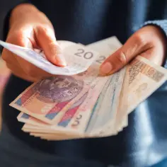 Ręce liczą polskie banknoty. Od kiedy 800 plus, pieniędzy jest więcej, ale czy starczy na wszystko?