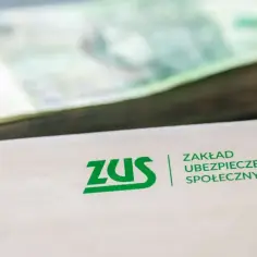 Koperta ZUS z logo i stosem banknotów. Symbolizuje to rentę po zmarłym ojcu, która zapewnia wsparcie finansowe.