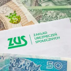 Koperta ZUS na tle polskich banknotów. Symbolizuje ubezpieczenie chorobowe i świadczenia socjalne.