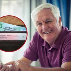 Uśmiechnięty senior z legitymacją emeryta w portfelu, korzystający z tabletu.