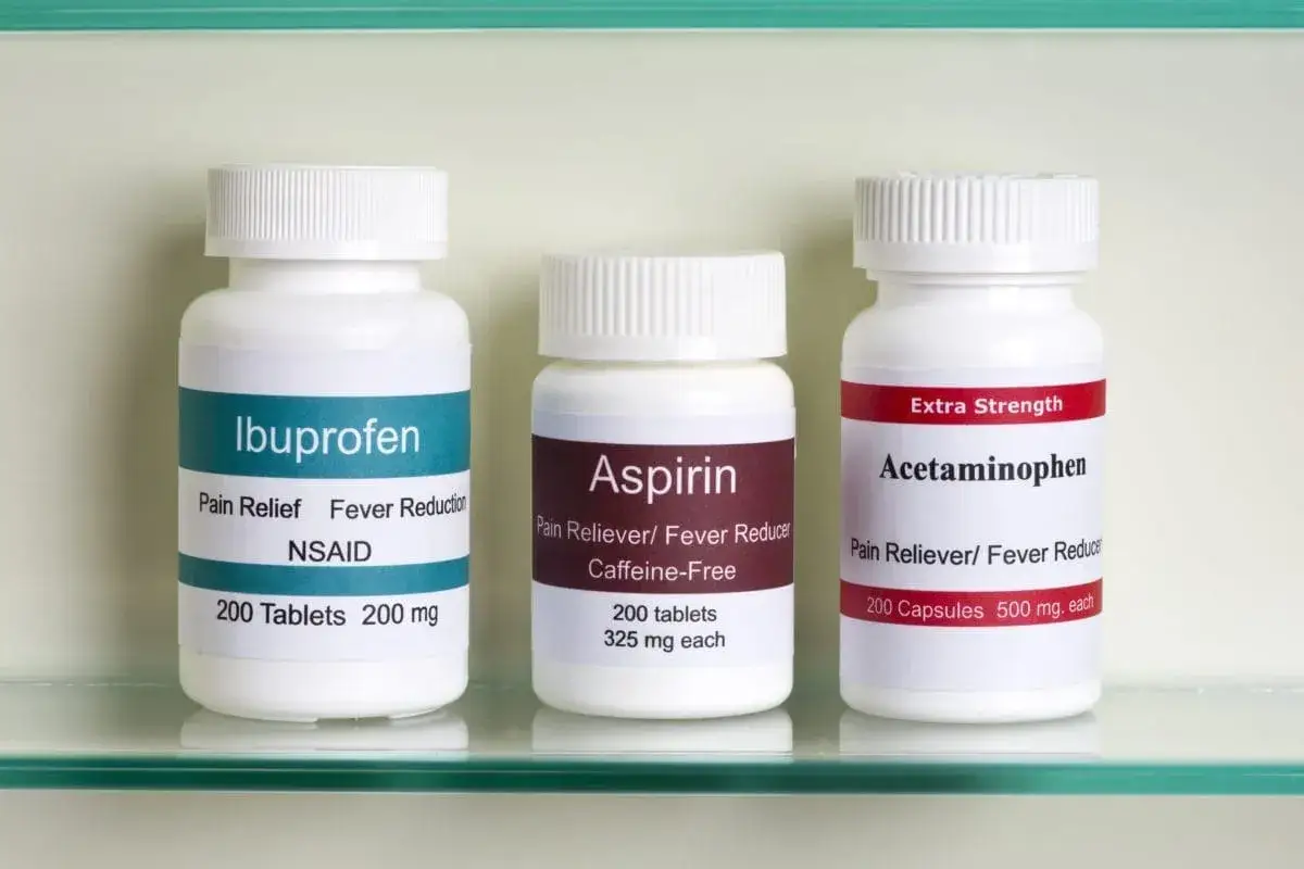 Trzy butelki leków: Ibuprofen, Aspiryna i Acetaminophen. Każdy z nich to potencjalnie najsilniejszy lek przeciwbólowy, w zależności od potrzeb.