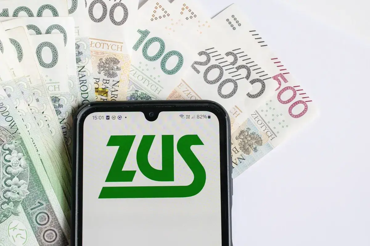 Telefon z logo ZUS na tle polskich banknotów. Czekamy na 14 emeryturę, licząc na dodatkowe środki.