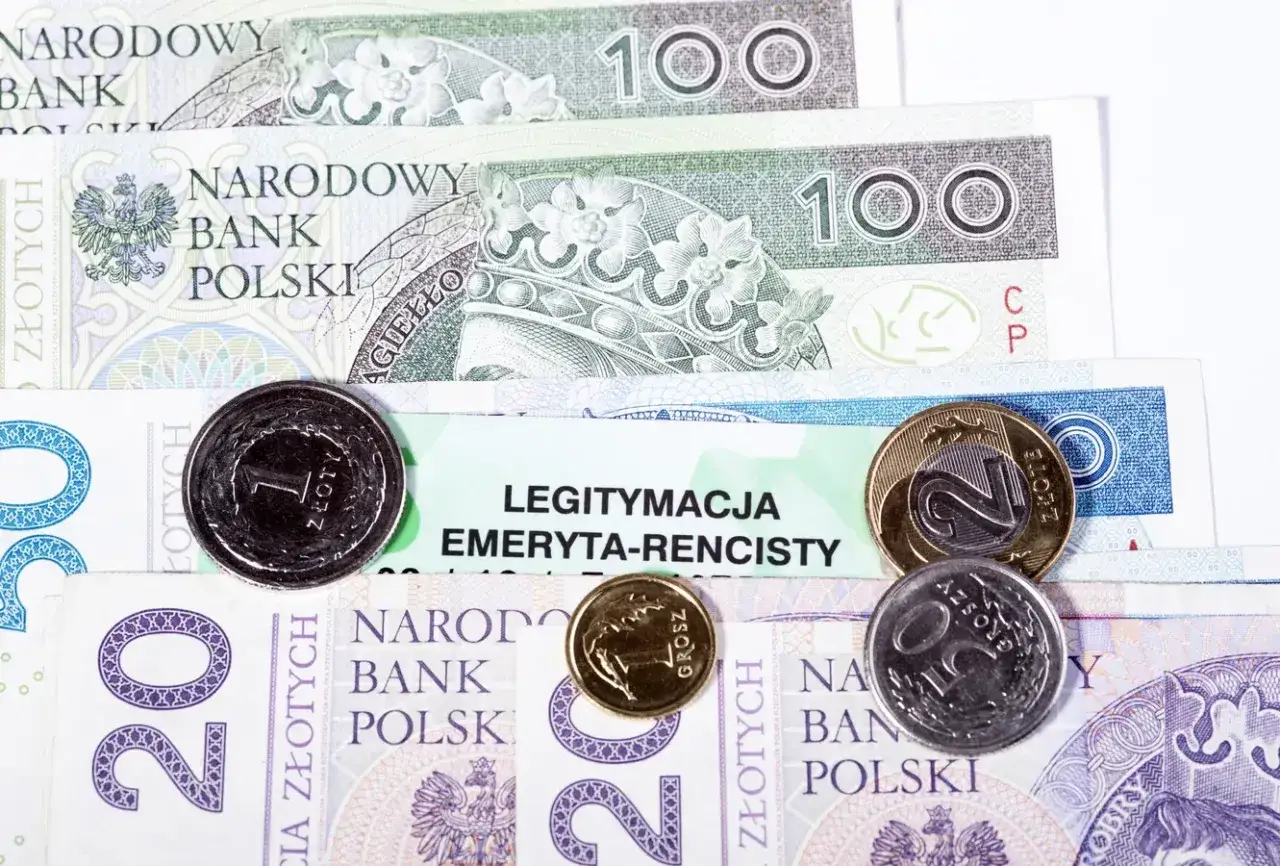 Legitymacja emeryta-rencisty leży na stosie polskich banknotów i monet.