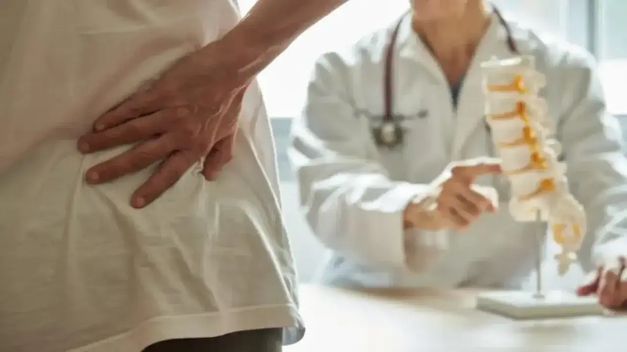 Lekarz omawia z pacjentem gabapentin na bóle kręgosłupa, wskazując na model kręgosłupa.